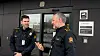To polititenestemenn snakkar saman framfor inngangsdør til politistasjon.
